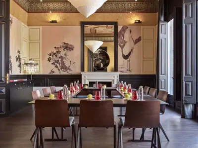 a dining room with a table and chairs and a mirror at Boutique Hotel H10 Catalunya Plaza in Barcelona