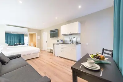 a living room with a bed and a table with a bowl of fruit at Senator Barcelona Apartments in Barcelona