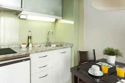a small kitchen with a sink and a table with at Senator Barcelona Apartments in Barcelona