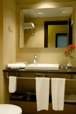 a bathroom with a sink and a mirror and towels at Senator Barcelona Apartments in Barcelona