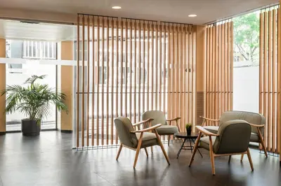 a lobby with chairs and a table and windows at Ronda House in Barcelona