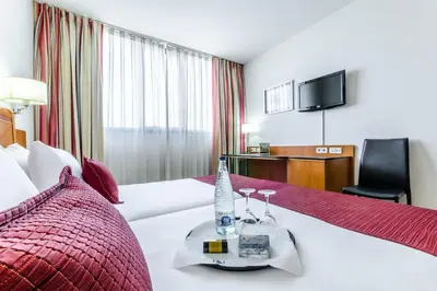 a hotel room with two beds and a television at Exe Barbera Parc in Barbera del Valles