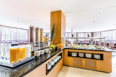 a restaurant with a buffet line with food at Exe Barbera Parc in Barbera del Valles