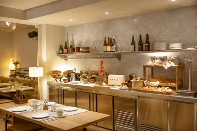 a kitchen with a table and a counter with food at Hotel Casa Teva Barcelona in Barcelona