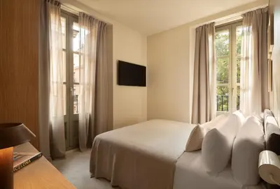 a bedroom with a bed and a large window at Hotel Casa Teva Barcelona in Barcelona