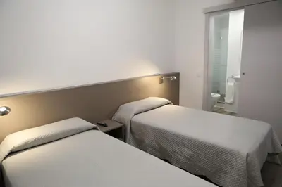 a room with two beds and a mirror at Hotel Alguer Camp Nou in Barcelona