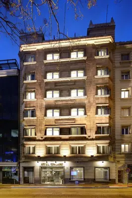 a tall building with lights on in front of it at Hotel Condado in Barcelona