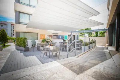 a patio with a table and chairs on a building at Atenea Park Suites & Apartments in Vilanova i la Geltrú