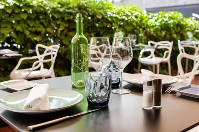 a table with a bottle of wine and glasses on it at Ibersol Antemare - Adults Only in Sitges