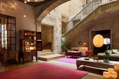 a living room with a staircase and a couch at Hotel Neri – Relais & Chateaux in Barcelona