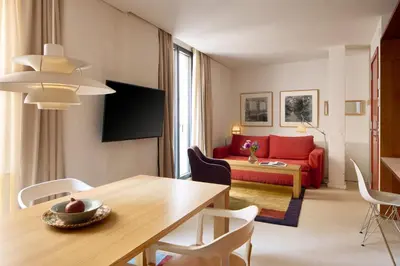 a living room with a table and a red couch at Hotel Neri – Relais & Chateaux in Barcelona