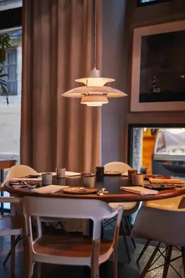 a dining room table with chairs and a light fixture at Hotel Neri – Relais & Chateaux in Barcelona