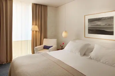 a bedroom with a white bed and a chair at Hotel Neri – Relais & Chateaux in Barcelona