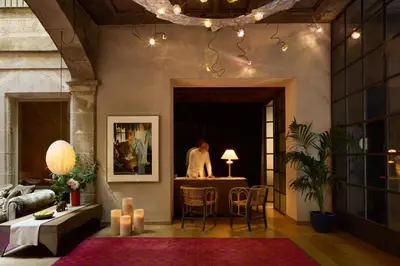 a living room with a table and a person in the background at Hotel Neri – Relais & Chateaux in Barcelona