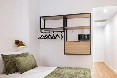 a small bedroom with a bed and a microwave at htop BCN City #htopEnjoy in Barcelona