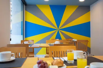 a cafeteria with tables and chairs with orange juice at Casual Colours Barcelona in Barcelona