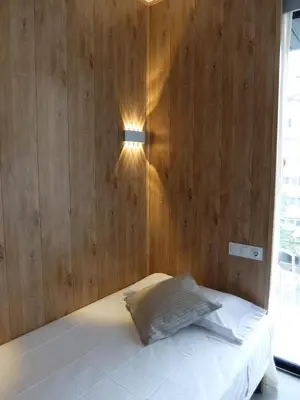 a bedroom with a bed with a wooden wall at Hotel Medicis in Barcelona
