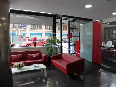 a living room with a red couch and a window at Hotel Medicis in Barcelona