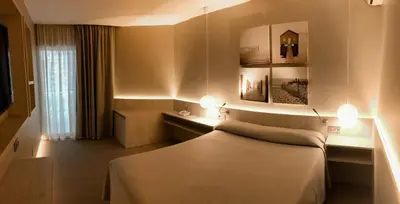 a hotel room with a bed and lights on it at Hotel Bernat II 4*Sup in Calella