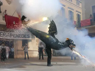 a man is holding a fire hydrant in the street at Tina de Vila, en la capital del vino in Vilafranca del Penedès