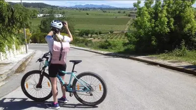 a woman standing next to a bike on a road at Tina de Vila, en la capital del vino in Vilafranca del Penedès