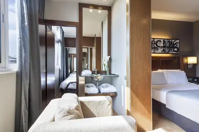 a hotel room with a bed and a mirror at Acta Atrium Palace in Barcelona