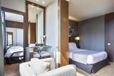 a hotel room with a bed and a mirror at Acta Atrium Palace in Barcelona