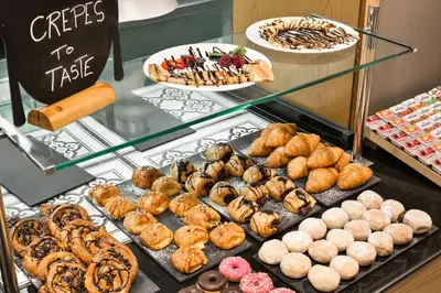 a display case filled with lots of different types of pastries at Acta Atrium Palace in Barcelona