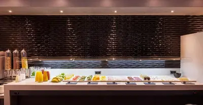 a buffet line with food on display in a restaurant at Ilunion Bel-Art in Barcelona