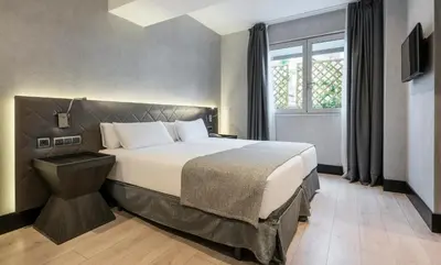 a bedroom with a large bed with a window at Ilunion Bel-Art in Barcelona