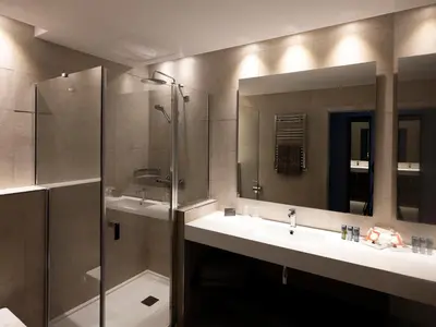 a bathroom with two sinks and a shower and a mirror at HG City Suites Barcelona in Barcelona