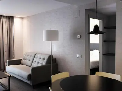 a living room with a couch and a table at HG City Suites Barcelona in Barcelona