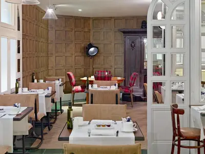 a restaurant with white tables and chairs and a room with wooden walls at Boutique Hotel H10 Montcada in Barcelona
