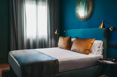a bedroom with a bed with blue walls and a window at Arenas Atiram Hotel in Barcelona