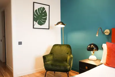 a bedroom with a green chair next to a bed at Arenas Atiram Hotel in Barcelona