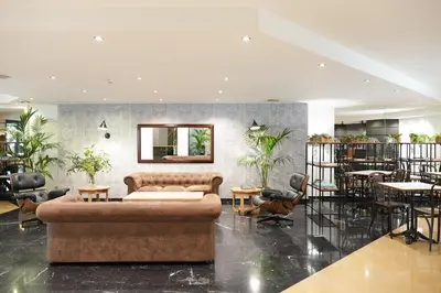 a lobby with a couch and tables and chairs at Arenas Atiram Hotel in Barcelona