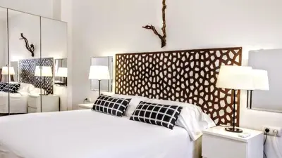 a bedroom with a large white bed and two lamps at BizFlats Garden House in Barcelona