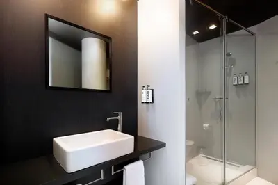 a bathroom with a sink and a glass shower at Wilson Boutique Hotel in Barcelona
