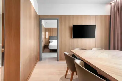 a room with a table and a tv on a wall at AC Hotel Diagonal L'Illa by Marriott in Barcelona