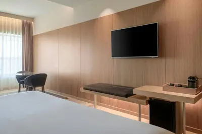 a hotel room with a bed and a television on a wall at AC Hotel Diagonal L'Illa by Marriott in Barcelona
