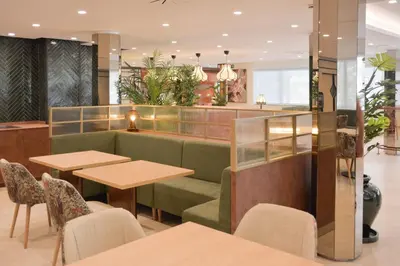 a restaurant with tables and a green couch at Hotel Viladomat in Barcelona