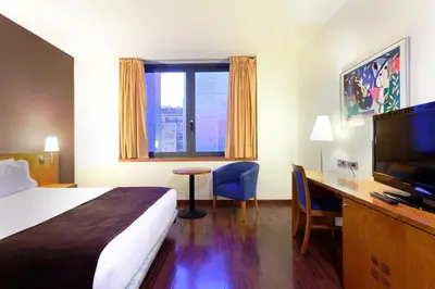 a hotel room with a bed and a desk and a television at Hotel Viladomat in Barcelona