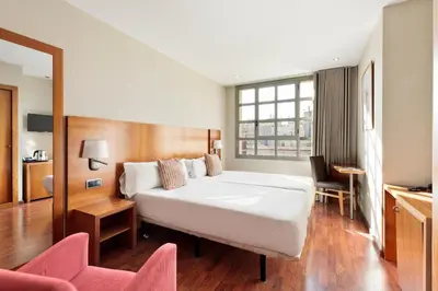 a hotel room with a large white bed and chairs at Hotel Best Aranea in Barcelona