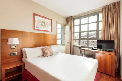 a hotel room with a bed and a desk and a window at Hotel Best Aranea in Barcelona