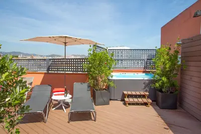 a balcony with an umbrella and chairs and a pool at Garbi Millenni in Barcelona