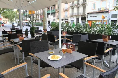 a restaurant with tables and chairs on a city street at Garbi Millenni in Barcelona