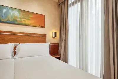 a bedroom with a white bed and a window at Garbi Millenni in Barcelona