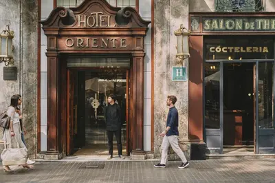 two people walking in front of a store at Oriente Atiram Hotel in Barcelona