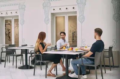 a group of people sitting at tables in a restaurant at Oriente Atiram Hotel in Barcelona