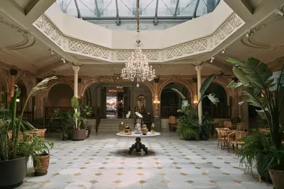 a large lobby with a chandelier and plants at Oriente Atiram Hotel in Barcelona